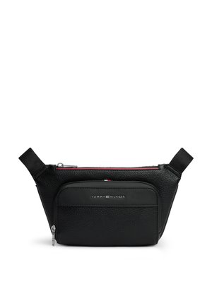 Banane en cuir noir Tommy Hilfiger avec poche zippée à l'avant et sangles latérales réglables sur fond blanc.