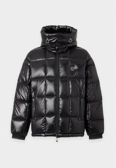 Veste matelassée noire brillante avec col montant, fermeture éclair complète à l'avant, poches latérales zippées et petit badge rond avec logo sur la poitrine.