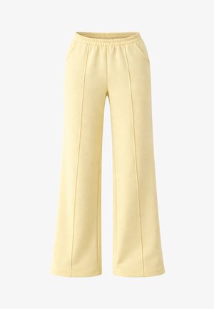 Pantalon large jaune clair avec taille élastique, détails de coutures au devant et poches latérales, conçu pour un usage décontracté.