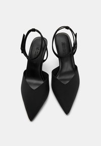 Black pointed-toe slingback heels with a matte finish, featuring a thin ankle strap and a smooth interior texture for comfort.