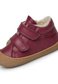 Scarpa in pelle marrone con strap in velcro, soffice fodera interna e suola in gomma. Punta arrotondata e dettagli cuciti sulla parte superiore.