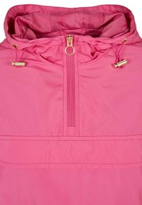 Różowa kurtka z kapturem, wyposażona w przedni zamek błyskawiczny sięgający do połowy, zakończony okrągłym suwakem, oraz regulowane sznurki z kaptura z zatrzaskami w kolorze złotym.