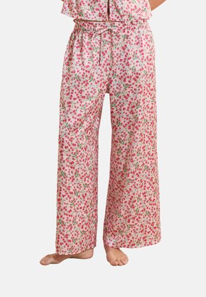 Pantalones de pijama de pierna ancha con estampado floral pequeño en rosa y rojo, cintura elástica y cordón, usados descalzos.