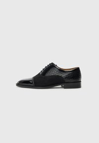 Black formal shoes featuring a combination of shiny patent leather and textured suede, with a rounded toe and a low heel.