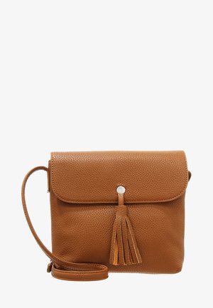 Sac bandoulière en cuir marron texturé avec fermeture à rabat et pompon décoratif, doté d'une longue sangle réglable.