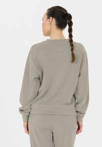 Grijze, zachte sweatshirt van stof met een relaxte pasvorm, ronde halslijn en ribgebreide manchetten. De merknaam "ENDURANCE" is subtiel op de achterkant vermeld.
