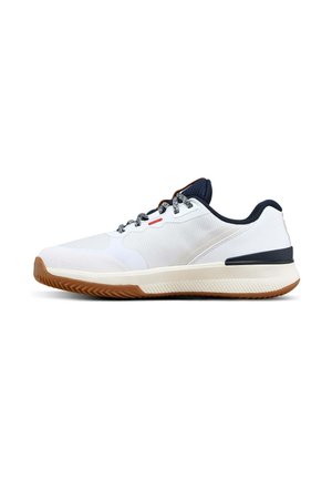 Witte sportschoen met zwart-witte veters, zwarte kraag en bruine rubberen zool, van opzij getoond op een witte achtergrond.