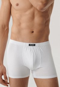 Białe slipy wykonane z miękkiej bawełny, z czarnym logo "ATLANTIC" na pasku, dopasowany krój o gładkiej fakturze.