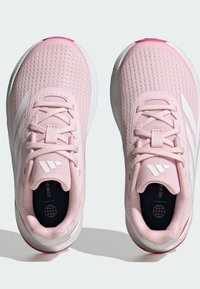 Scarpe da ginnastica rosa chiaro con parte superiore in rete texturizzata, dettagli bianchi e lacci. Presentano un collare imbottito e un logo sulla soletta interna.