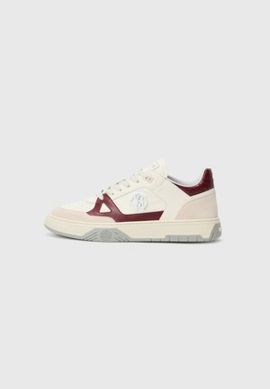 Low-top sneaker with cream, beige, and burgundy panels, white laces, and logo emblem on the side and gray rubber sole.