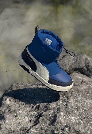 Bottes imperméables bleues et marine avec un haut rembourré, en cuir lisse et texturé, présentant un logo sur le côté et une fermeture à cordon.