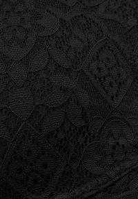 Černá krajková textilie s květinovými a geometrickými vzory, složitými detaily a hladkou strukturou. Vhodná pro oděvní aplikace.