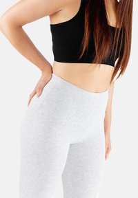 Szare legginsy wykonane z miękkiego, elastycznego materiału z wysokim stanem. Projekt cechuje gładka faktura i brak widocznych szwów.