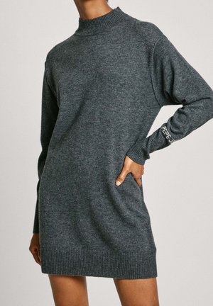 Dunkelgraues, langärmliges Strickkleid mit geripptem Kragen und Saum, Hand des Models ruht auf der Hüfte, "PEPE"-Schriftzug auf der linken Ärmelmanschette.