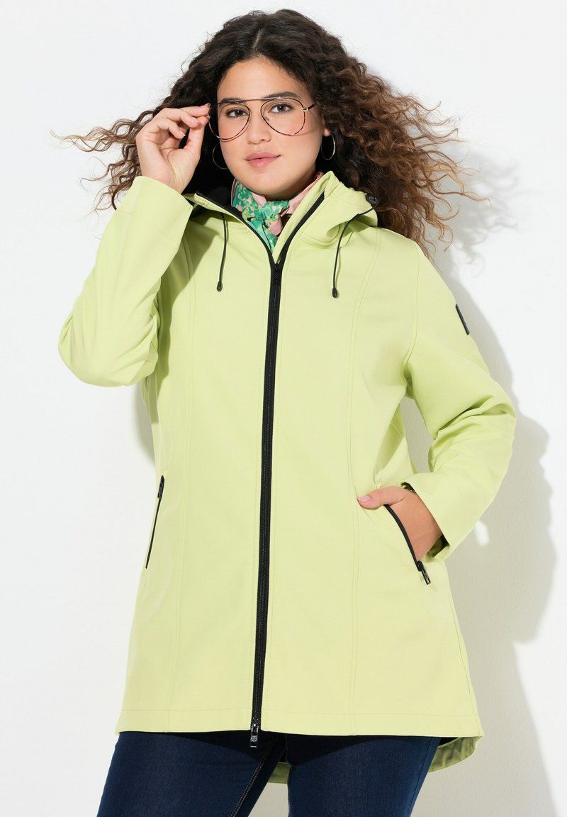Giacca a vento verde chiaro con cappuccio, chiusura con zip, lacci elastici e tasche laterali. Presenta una texture liscia e un design a vestibilità rilassata.