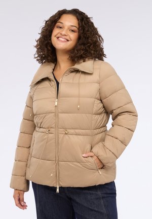 Doudoune beige avec fermeture éclair à l'avant, taille ajustable avec cordon de serrage et grand col. Présente des coutures horizontales et des accents en métal doré.