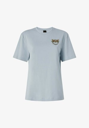 T-shirt azzurro chiaro a maniche corte con scollo rotondo e piccolo motivo decorativo di farfalla e anello con perline sul lato sinistro del petto.