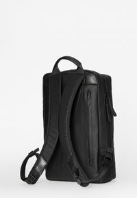 Schwarzer rechteckiger Rucksack mit gepolsterten Schultergurten, oberem Griff und vertikalem Reißverschlussfach auf der Rückseite, schräg dargestellt, um Seiten- und Rückansicht zu zeigen.