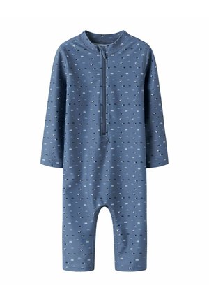 Sinine pikakarvaline beebidel body, millel on väikesed valged ja mustad auto mustrid ning ees lukuga, mis ulatub kaelast keskmise rinnani.