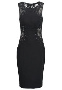 Robe noire à design sans manches, accents en dentelle au niveau du décolleté et sur les côtés, silhouette ajustée, embellie de sequins pour les détails.