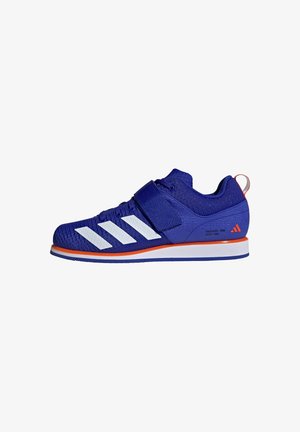 Paarse sportshoe met een bovenwerk van mesh, witte strepen en een klittenbandsluiting. Bevat een oranje accent op de zool en de hieltab.