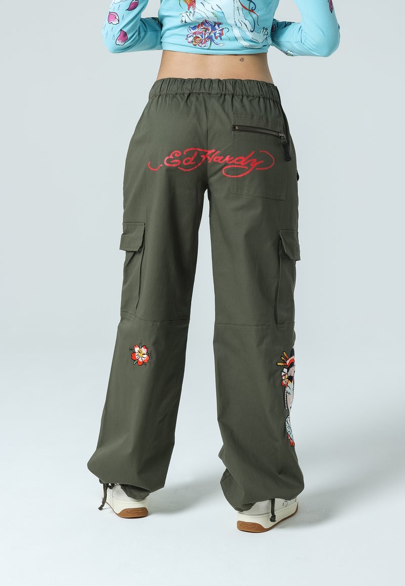 Olivgröna cargo-byxor med avslappnad passform, prydda med broderade blommönster och en logotyp i röd. Inkluderar sidfickor och en ficka med dragkedja.