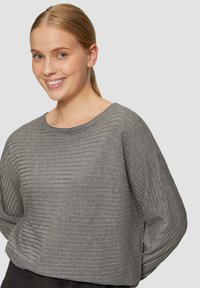 Grauer gerippter Pullover mit rundem Ausschnitt und langen Ärmeln. Besitzt ein strukturiertes Design mit abwechselnd hervorgehobenen Streifen. Weiches Material.