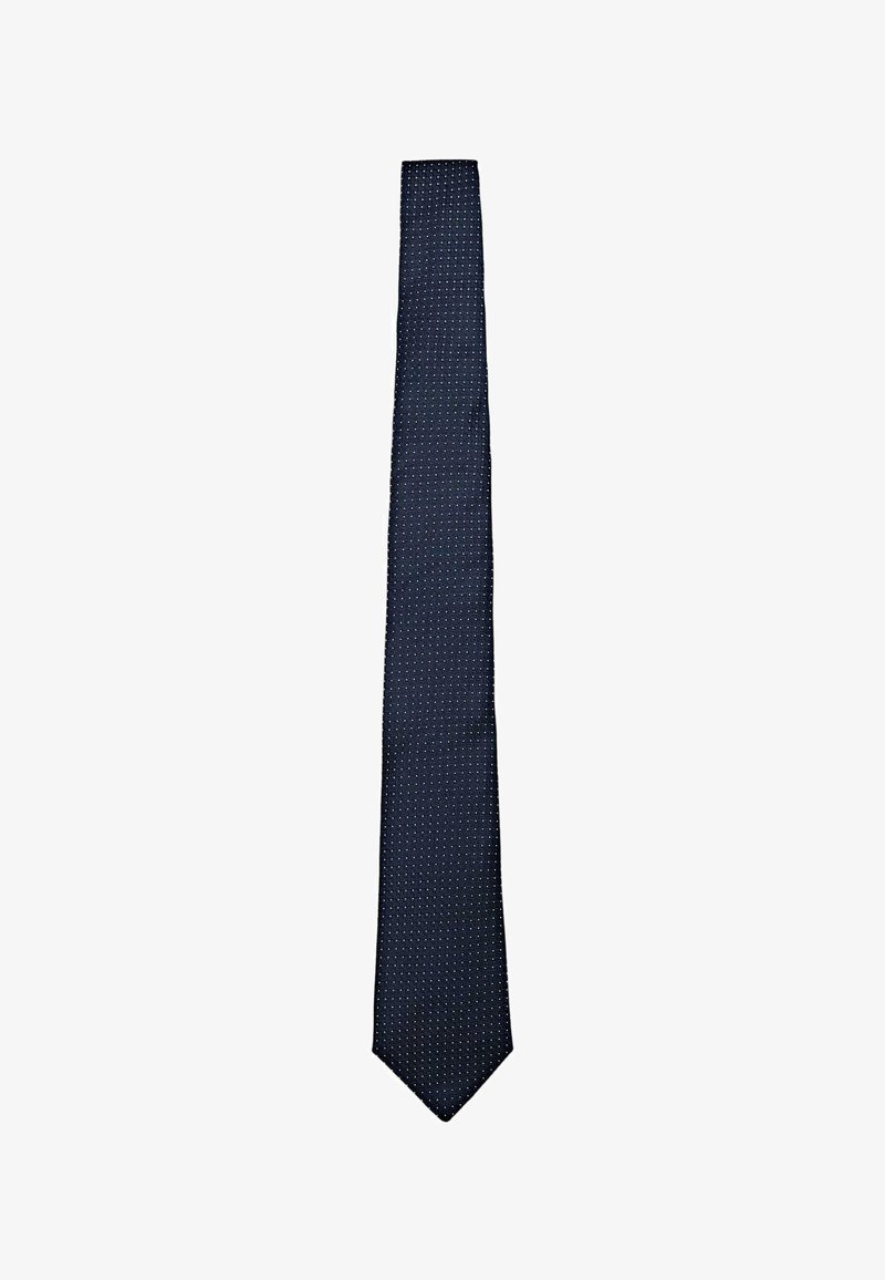 Cravate bleu marine en soie avec une surface texturée, présentant un motif de petits points blancs uniformément espacés. Design étroit avec une pointe pointue.
