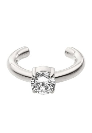 Open silver ring with a single round clear gemstone set in a four-prong setting, shown against a white background.