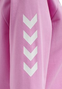 Manica di un indumento rosa con quattro strisce bianche a chevron orientate verso il basso, allineate verticalmente.