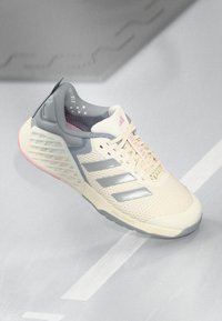 Pantofii sport bej și gri cu accente roz, dungi argintii Adidas, "Heat.RDY" pe sfori și talpă cu amortizare, concepuți pentru confort și performanță.