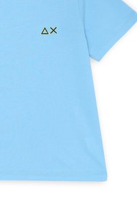 T-shirt azzurro chiaro realizzato in tessuto morbido, con maniche corte e un piccolo design geometrico ricamato in verde scuro sulla parte frontale.