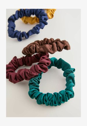 Rinkinys iš keturių audinio gumelių: tamsiai mėlynos, geltonos, burgundiškos ir žalsvos. Kiekviena turi suglamžytą dizainą ir lygią, elastingą tekstūrą.