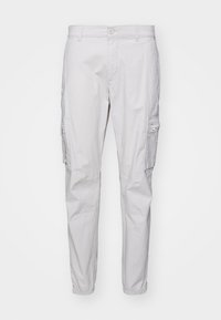 Vaaleanharmaat puuvillaiset cargo-housut, joissa säädettävät lahkeensuut, useita sivutaskuja ja tasainen etuosasuunnittelu. Sileä tekstuuri.