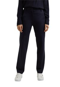 Námořnické kalhoty s úzkým střihem, vybavené zapínáním na knoflík a kapsami. Vyrobeno z hladké tkaniny, doplněné bílými botami.