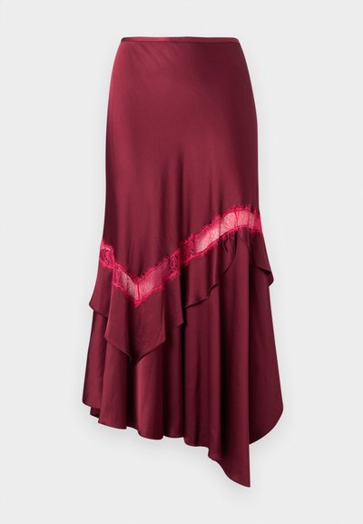 Asymmetrische bordeauxrode rok met diagonale kanten rand en gelaagde ruches, afgebeeld tegen een effen achtergrond.