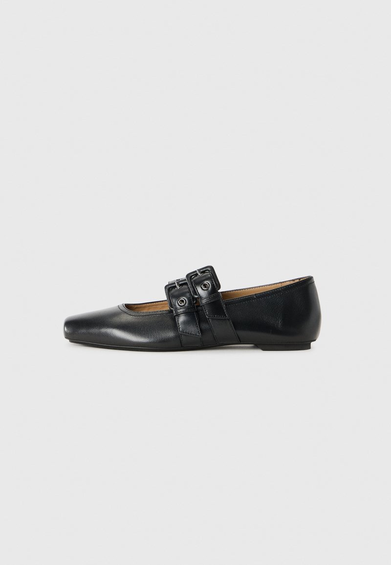 Chaussure plate en cuir noir avec un bout carré, ornée de doubles boucles sur le dessus. Design épuré avec un petit talon. Texture lisse.