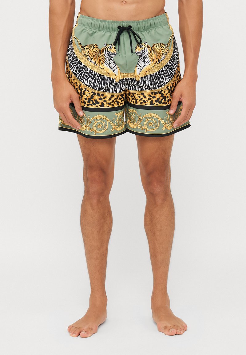 Grønne badetights med mønster af tiger- og leoparddesign, med elastisk talje, snøre og kontrasterende sort kant.