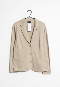 Ljusbrun blazer i stickad kvalitet, med enkelknap design, slagkragar, fyra knappar och två framfickor.