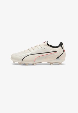 White soccer cleat with black and red Puma logo, lace-up design, and studded sole for traction on grass surfaces.