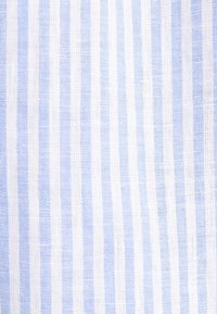 Texture de tissu à rayures verticales bleues et blanches avec une apparence légère et tissée.