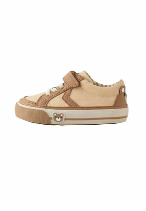 Baskets beige et marron pour tout-petit avec une bride velcro, des lacets blancs et une décoration représentant un visage d’ours en peluche sur le côté et le talon.