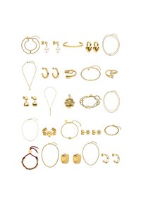 Collectie van gouden sieraden, waaronder oorringen, kettingen, armbanden en ringen met verschillende texturen, vormen en decoratieve elementen.