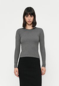 Gray, long-sleeve fitted top, ribbed texture, round neckline. Paired with a black pencil skirt, the outfit has a clean, minimalist look.