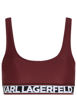 Bordeaux sportbeha met brede schouderbanden en een dikke zwarte band met witte tekst. Gladde textuur met stikseldetails.