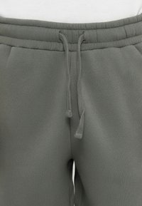 Graue Sweatpants mit elastischem Bund und Kordelzug. Weicher Stoff mit lockerer Passform. Keine sichtbaren Muster oder Beschläge.