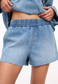 Jeansshorts med resårmidja, avklippt nederkant och blekt blå tvätt. Har sidofickor och synliga sömnadsdetaljer.