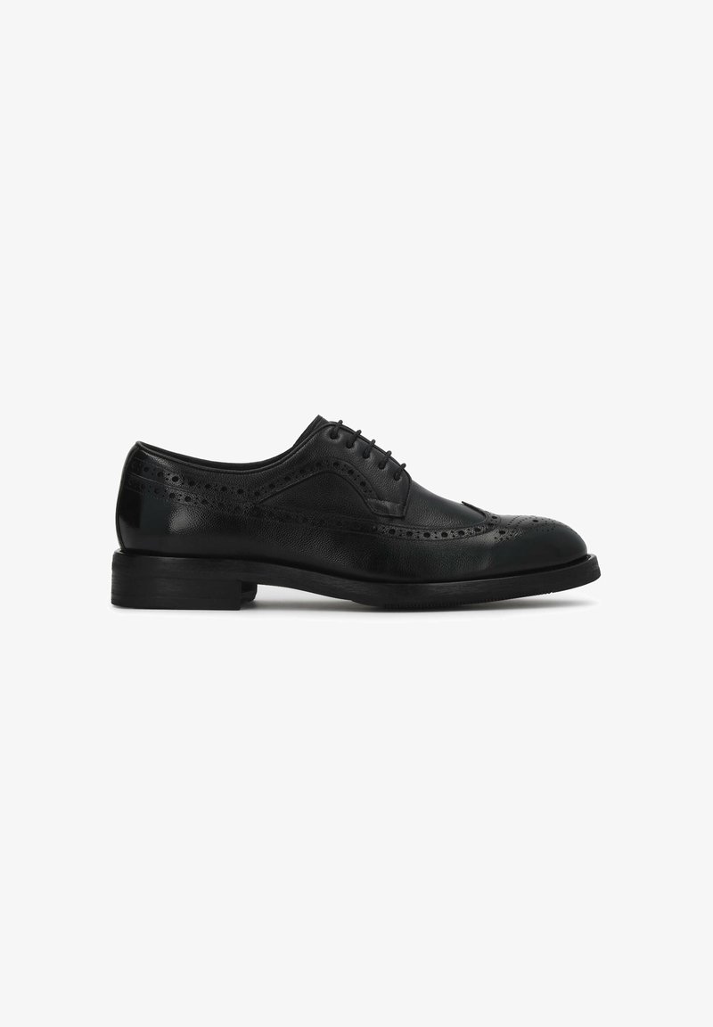 Chaussure brogue pour homme en cuir noir avec détails perforés, fermeture à lacets et petit talon empilé, vue de profil.