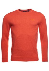 Pull rouge à manches longues, col rond et poignets côtelés. Confectionné dans un matériau doux et texturé. Présente une broderie de logo subtile.