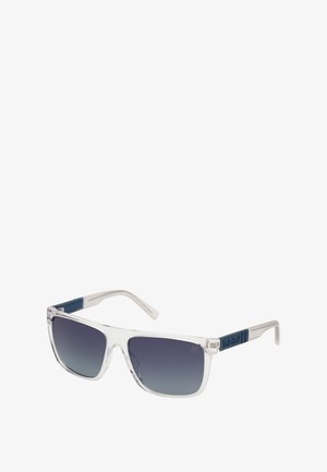 Gafas de sol con montura transparente, lentes de gradiente gris y patillas azules con un patrón que presenta un logo. Forma cuadrada con un diseño elegante.